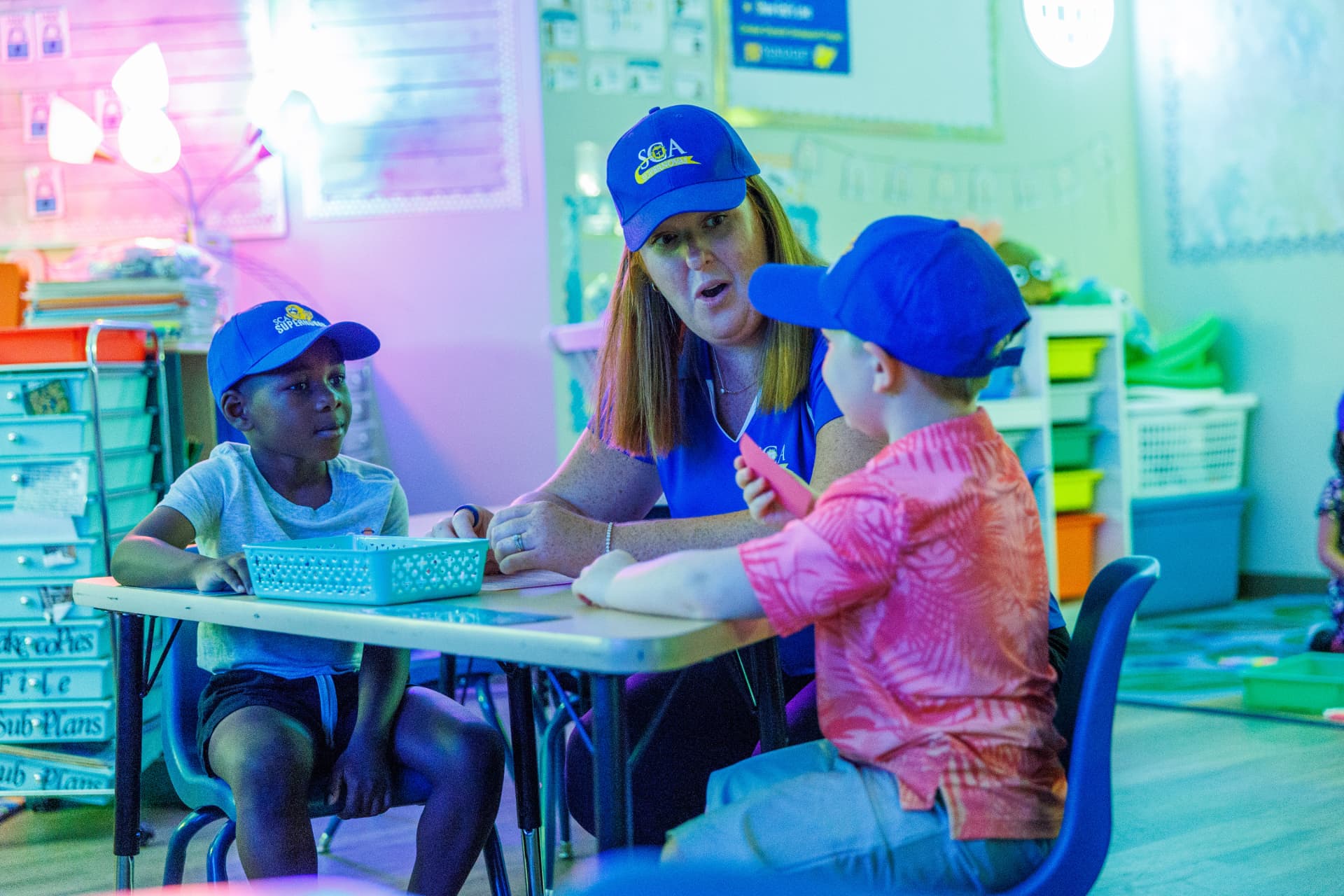 Sunlight teacher engaging with two students in a preschool classroom