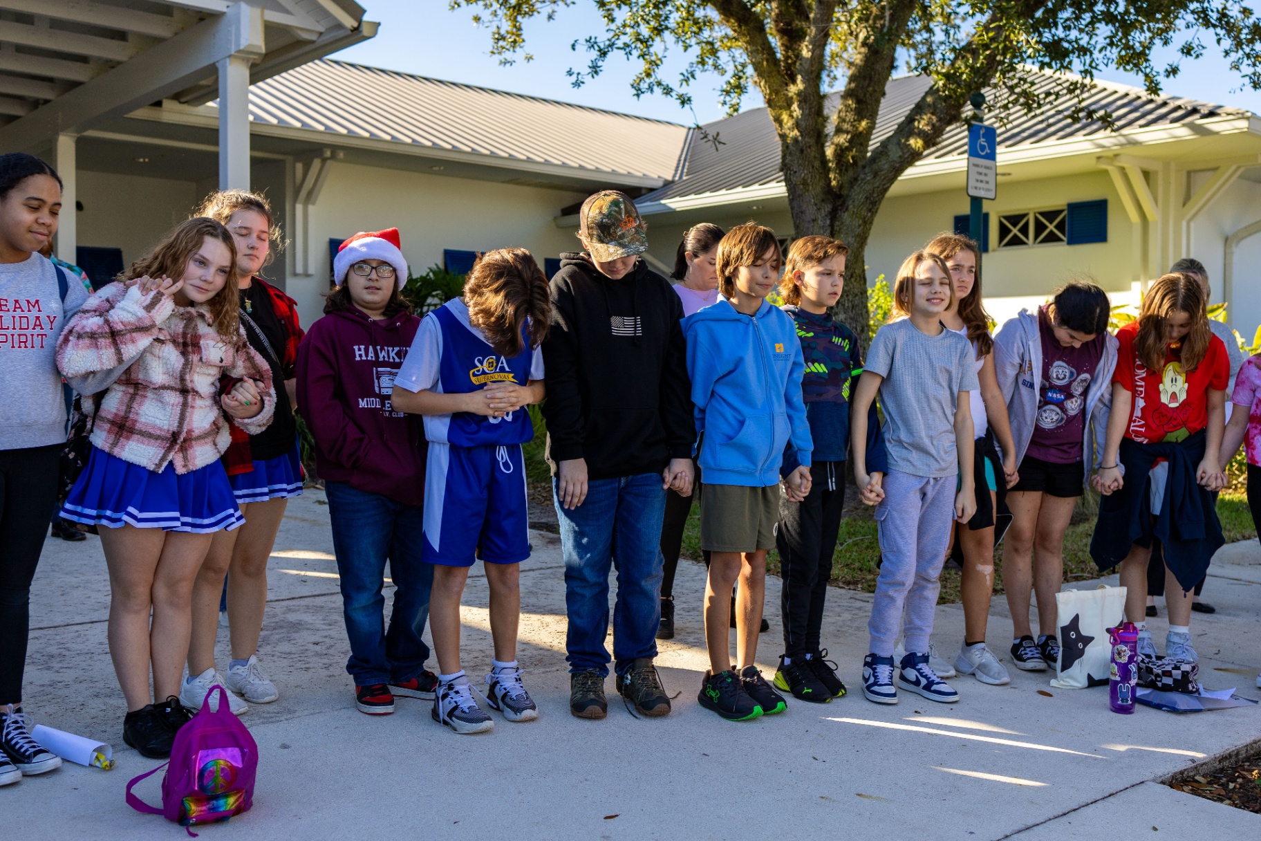 Students holding hands in prayer